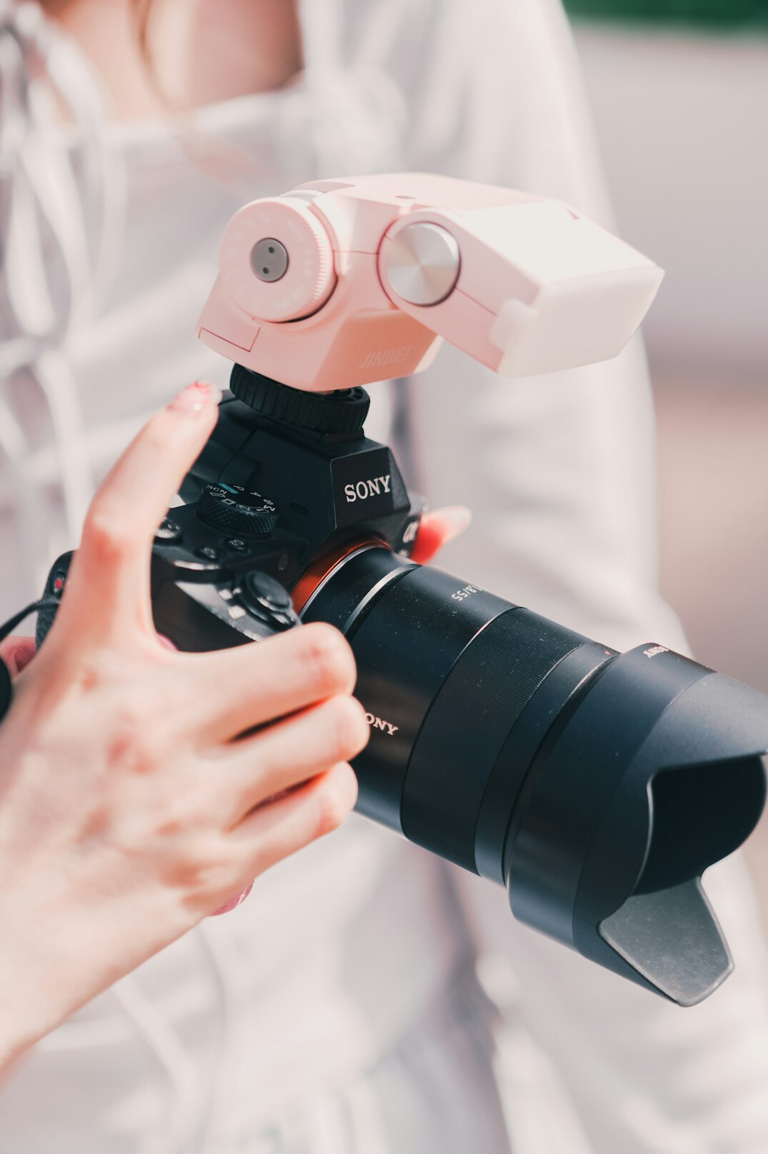 Young woman holding a professional video camera in front of her face